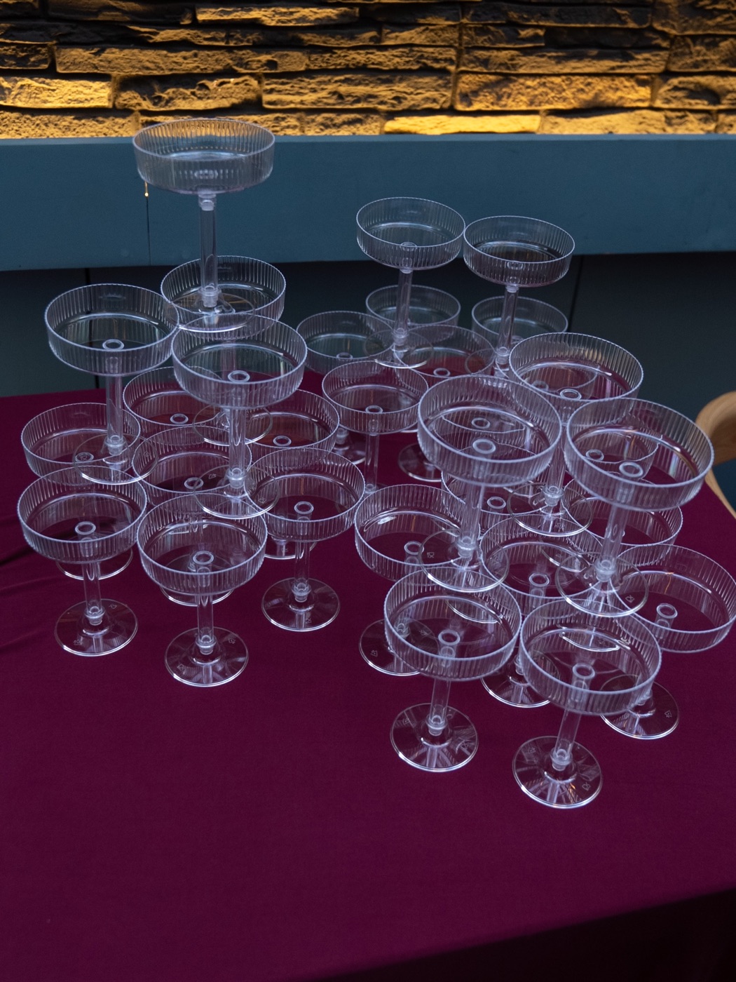 Coupe glasses stacked into a tower, catching the light, ready before guests arrived