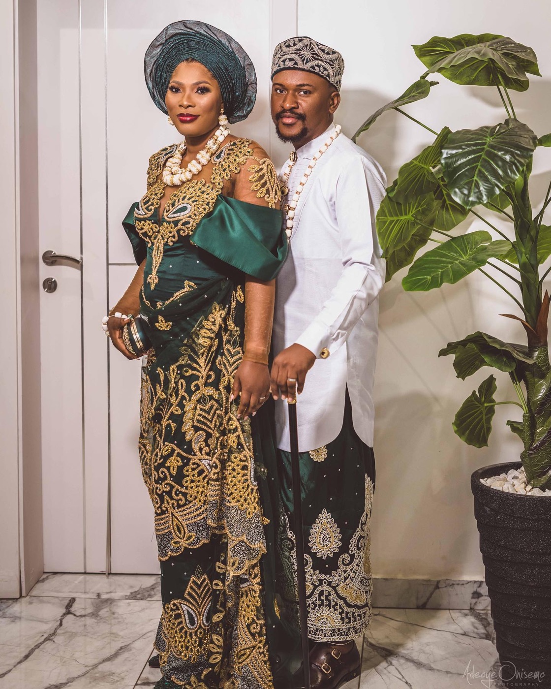 A couple in emerald and gold traditional dress, walking together