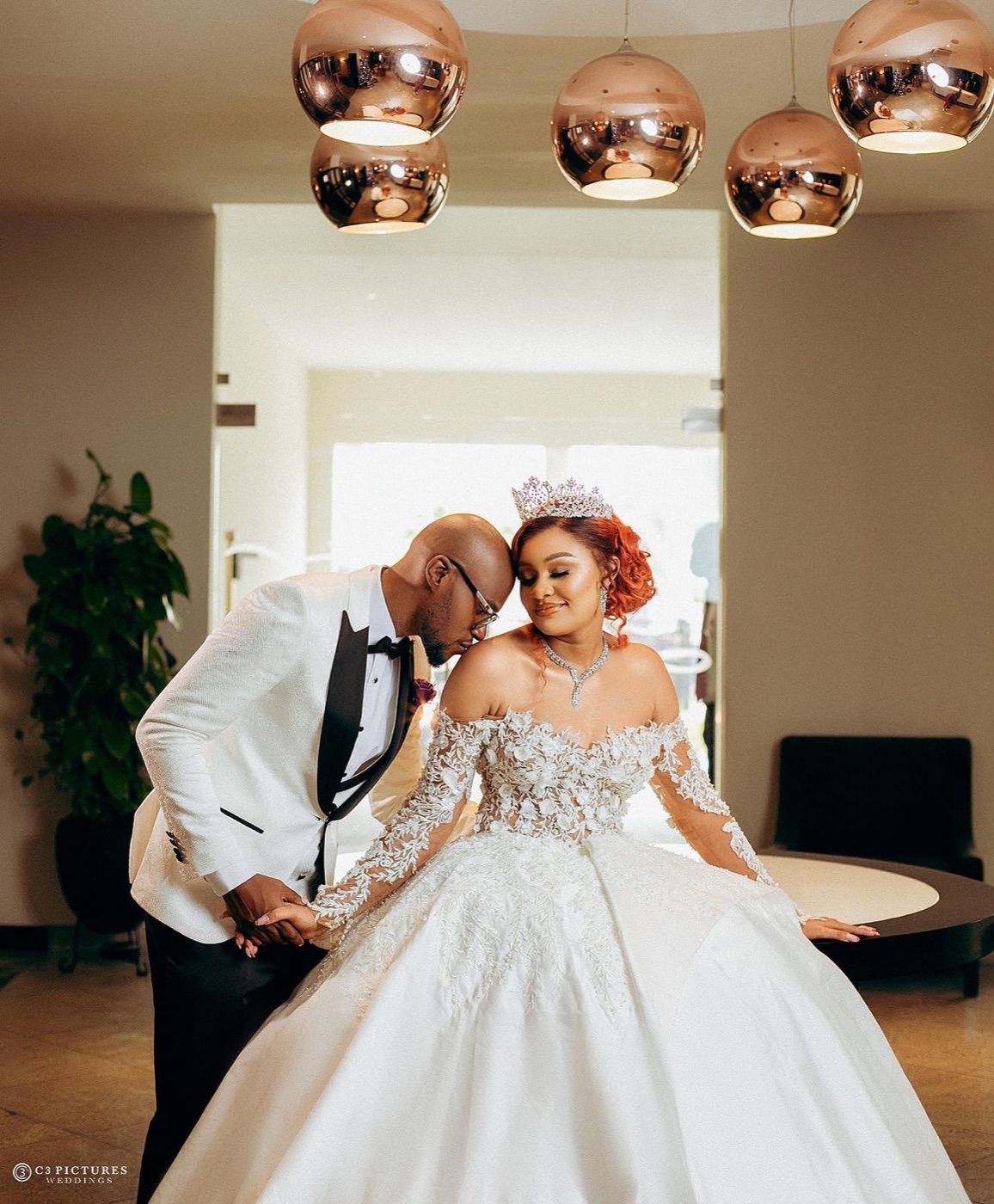 A bride in a full ballgown dancing with her groom in a white tuxedo